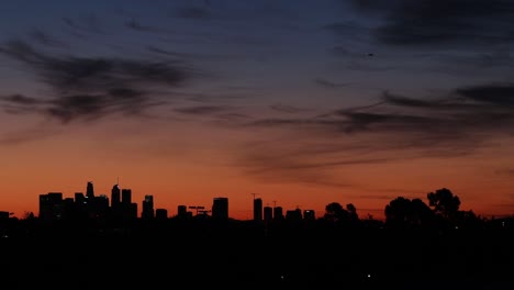 twilight downtown buildings silhouette with plane flying by