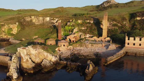 porth wen abandoned coastal derelict brickworks remains golden sunrise countryside bay aerial view orbit right