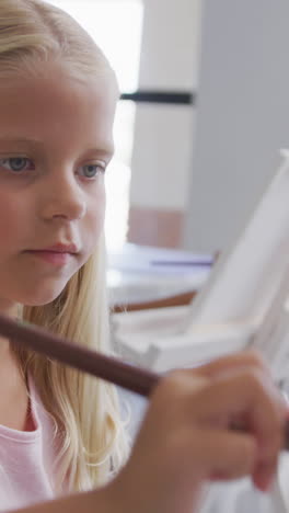 video of focused caucasian girl painting during art lessons at school