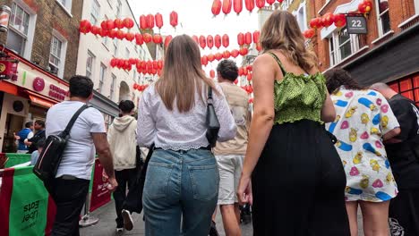 people walking under lanterns in chinatown, london