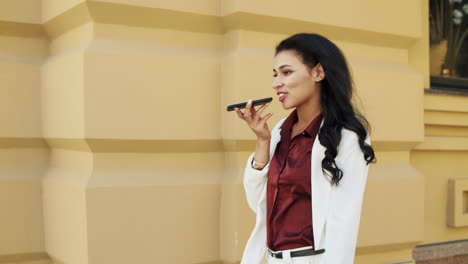 friendly businesswoman using speakerphone outside. young woman talking phone