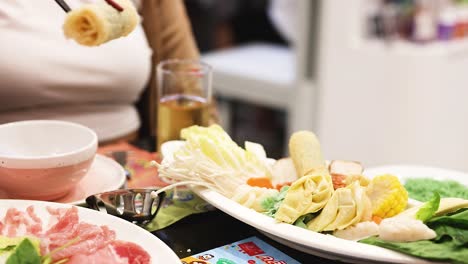 chopsticks picking food from a hotpot dish