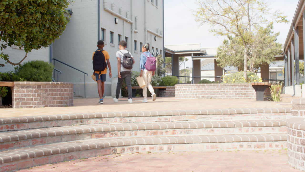 multiracial students walking to school with backpacks and lunch bags, copy space