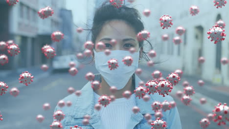 animation of covid 19 virus cells over woman wearing face mask