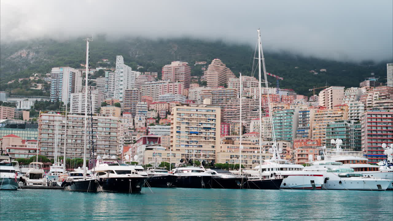 View of boats docked in the Monaco Marina with the skyline of the city on the background