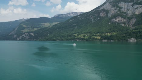 beautiful switzerland landscape of huge mountains,turquoise lake with ship