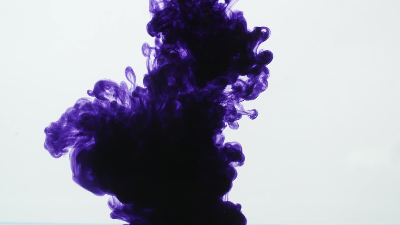 Purple Ink Drop Into Water On A White Background