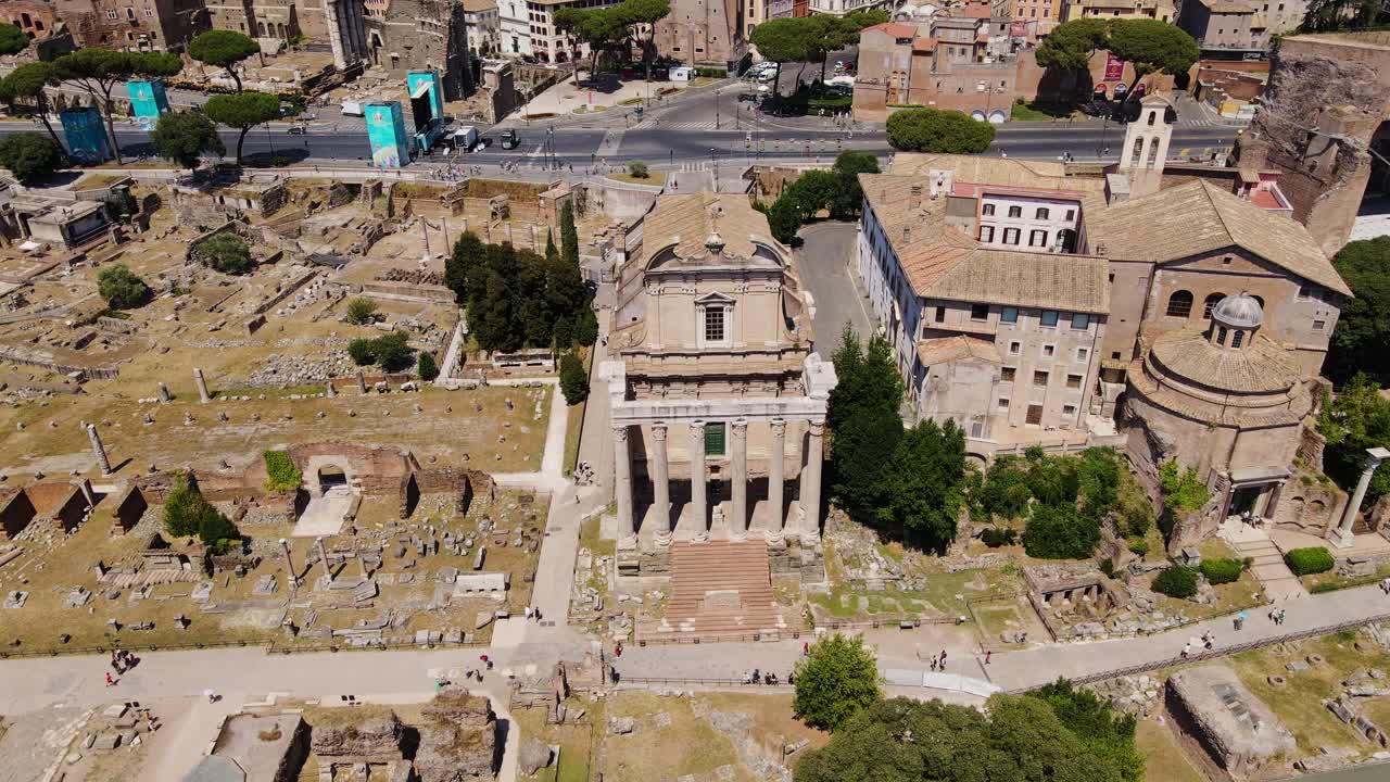 Historic Antoninus and Faustina temple rises above sunlit ancient ruins in Rome