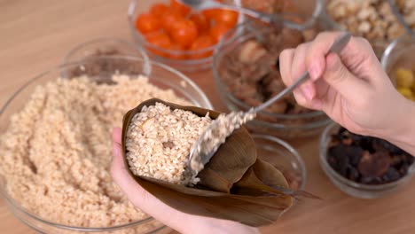 hacer comida zongzi - preparar y envolver dumplings de arroz chinos.