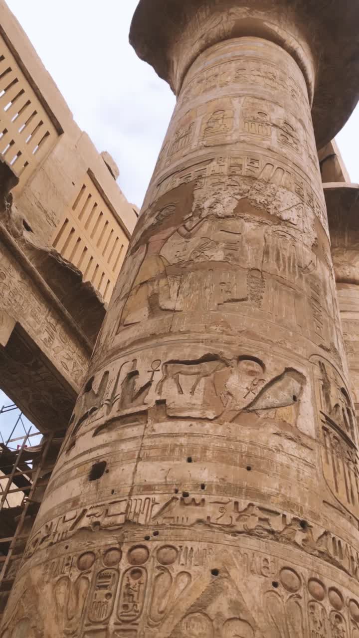 Primo piano con panoramica verso il basso di una colonna di un antico tempio egizio con geroglifici