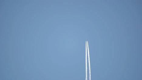 contrails of a commercial aircraft flying in clear sky