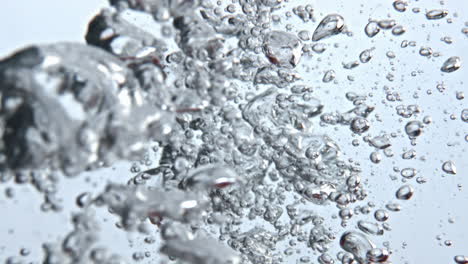 red fruits immersed liquid bubbles closeup. raw food making splashes water glass