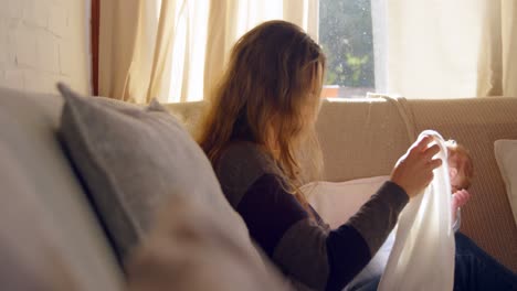 Mother-cleaning-her-baby-face-in-living-room-4k