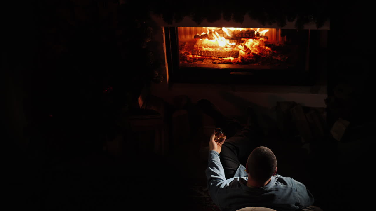 한 남자가 벽난로 꼭대기에서 브랜디를 마신다