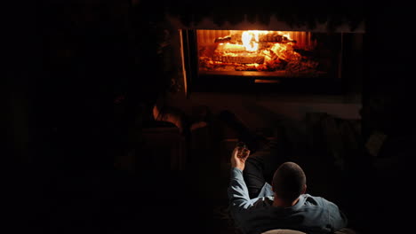 a man drinks brandy by the fireplace top view