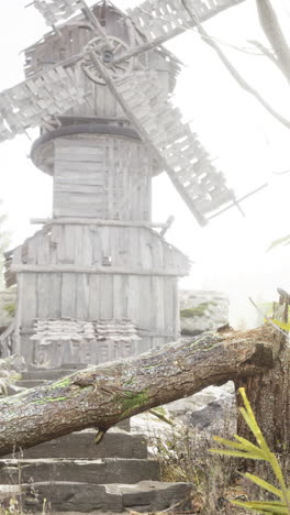 old wooden windmill in a misty landscape