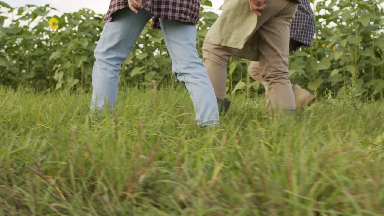 Unrecognizable Farmers Walking In Field