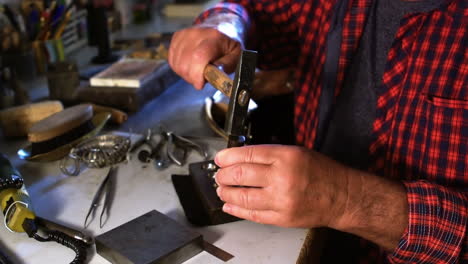 Close-up-of-goldsmith-making-hole-in-sinking