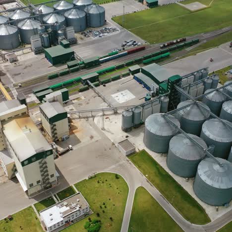 granary on green field. elevator on outdoor plant. steel agricultural containers for grain. aerial view.