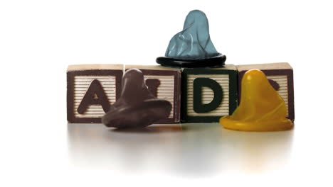 three condoms falling on blocks spelling aids