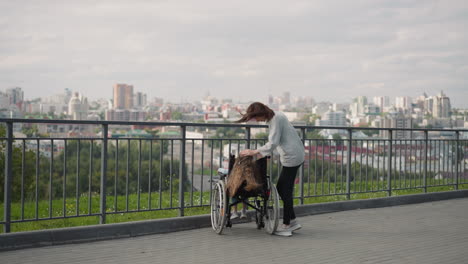 Madre-Pone-La-Mano-Sobre-La-Cabeza-De-Su-Hija-Sentada-En-Silla-De-Ruedas