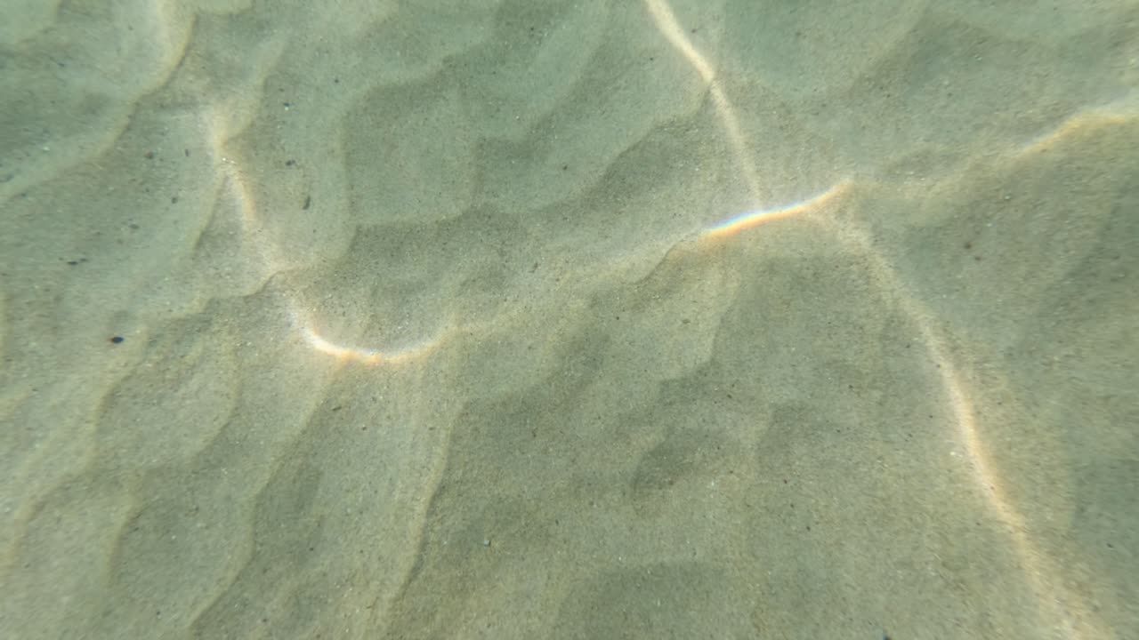 태국 푸켓의 모래 바다 바닥에서 역동적인 패턴을 만드는 빛의 수중 풍경. 부드러운 물의 움직임은 조용한 분위기를 향상시니다.