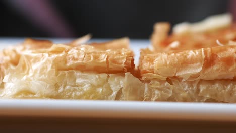 closeup of a flaky pastry on a white plate