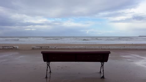 a solitary bench on the atlantic ocean promenade with crashing waves.