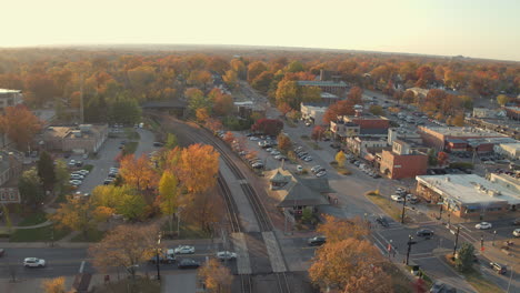 aerial view of downtown kirkwood at train station with cars crossing the tracks in the fall at golden hour in november with a rise