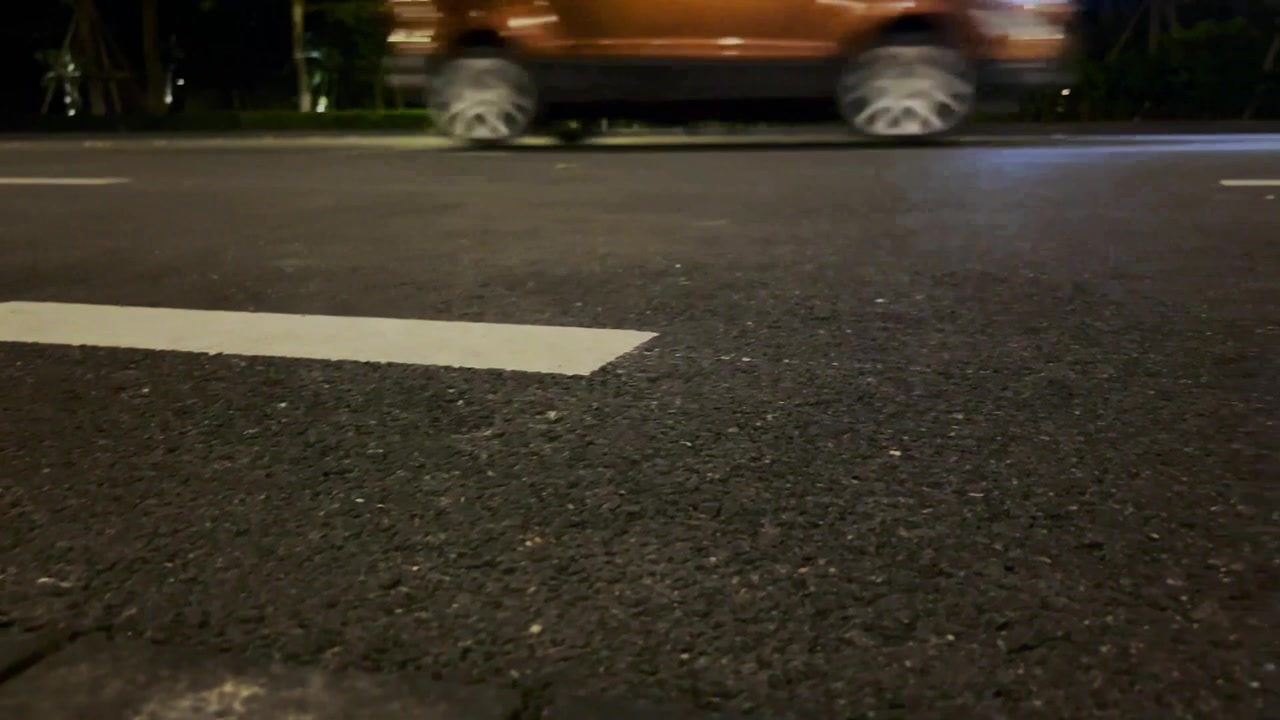 Car Driving on City Street at Night