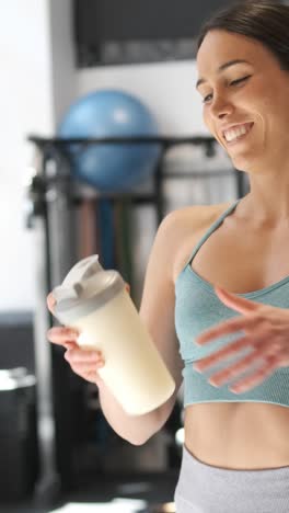 woman with protein shake at the gym