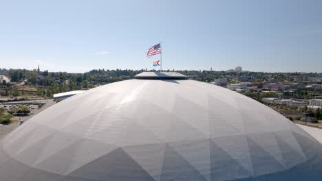 tacoma dome with pride flag and usa flag to celebrate and honor the lgbtq+ community in washington, usa. - aerial static shot
