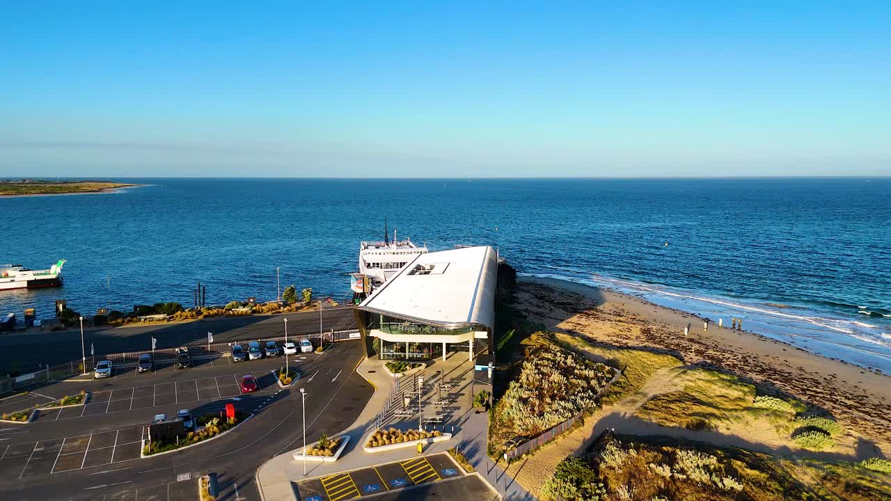 Aerial footage captures the Queenscliff Ferry Terminal in Bellarine, Victoria, with clear skies and calm ocean waters