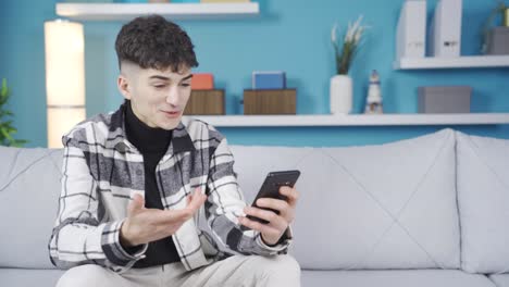 Un-Joven-Mirando-El-Teléfono-Se-Regocija.