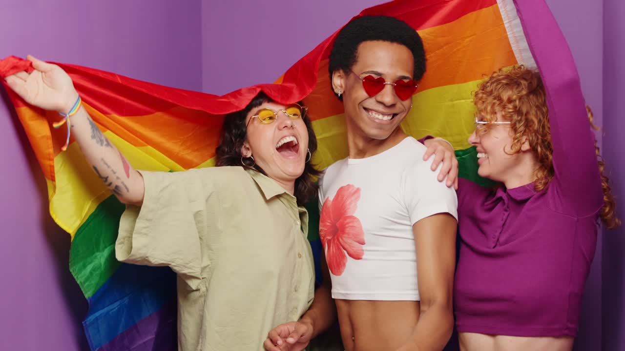 Friends celebrating LGBTQ Pride with a rainbow flag