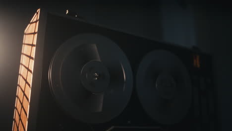 a vintage tape recorder spinning spools in a red blinking light