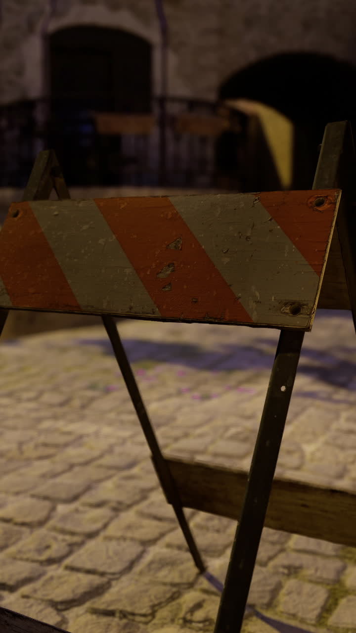Barriera di costruzione su strada acciottolata in una città vecchia al crepuscolo