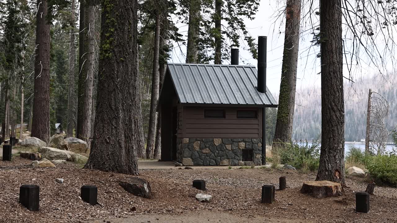 baño exterior de piedra en un campamento por un lago estático