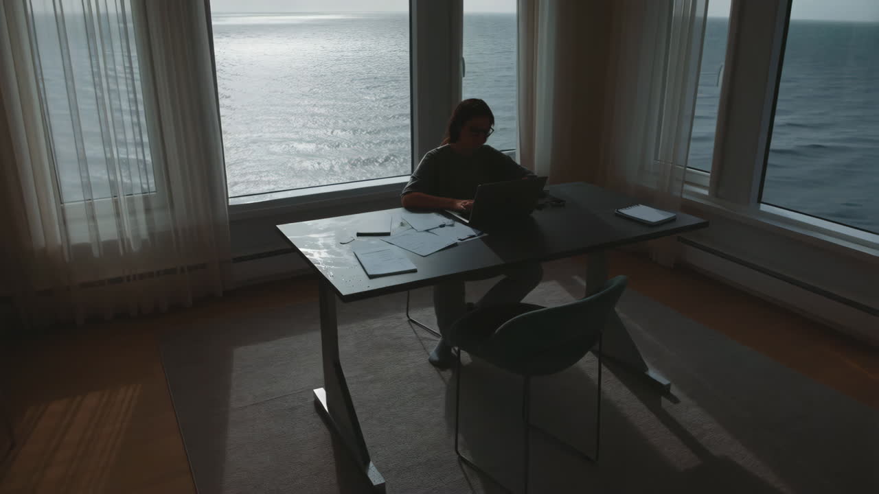 Person Working on Laptop with an Ocean View