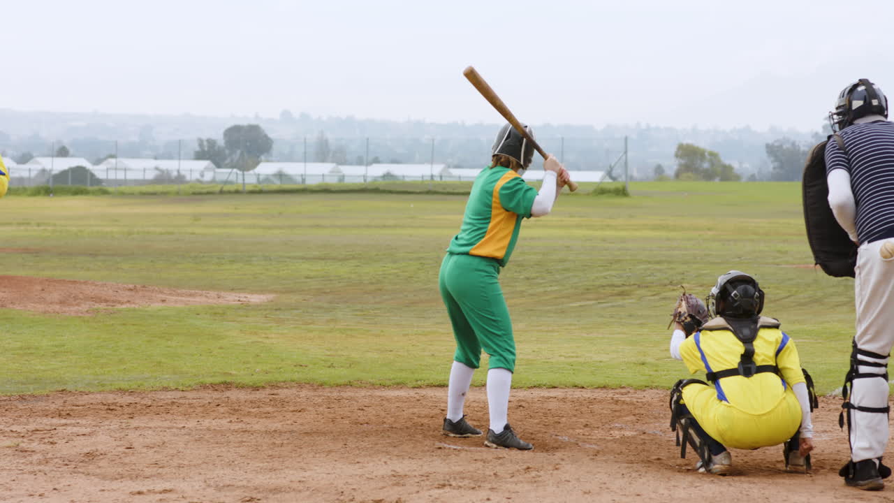 Multiracial female baseball players and male umpire, hitting ball with bat and running on a pitch