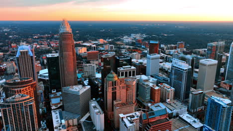 buildings in the city uptown lit with orange light at sunset. scenery of american city of charlotte, nc, usa from top