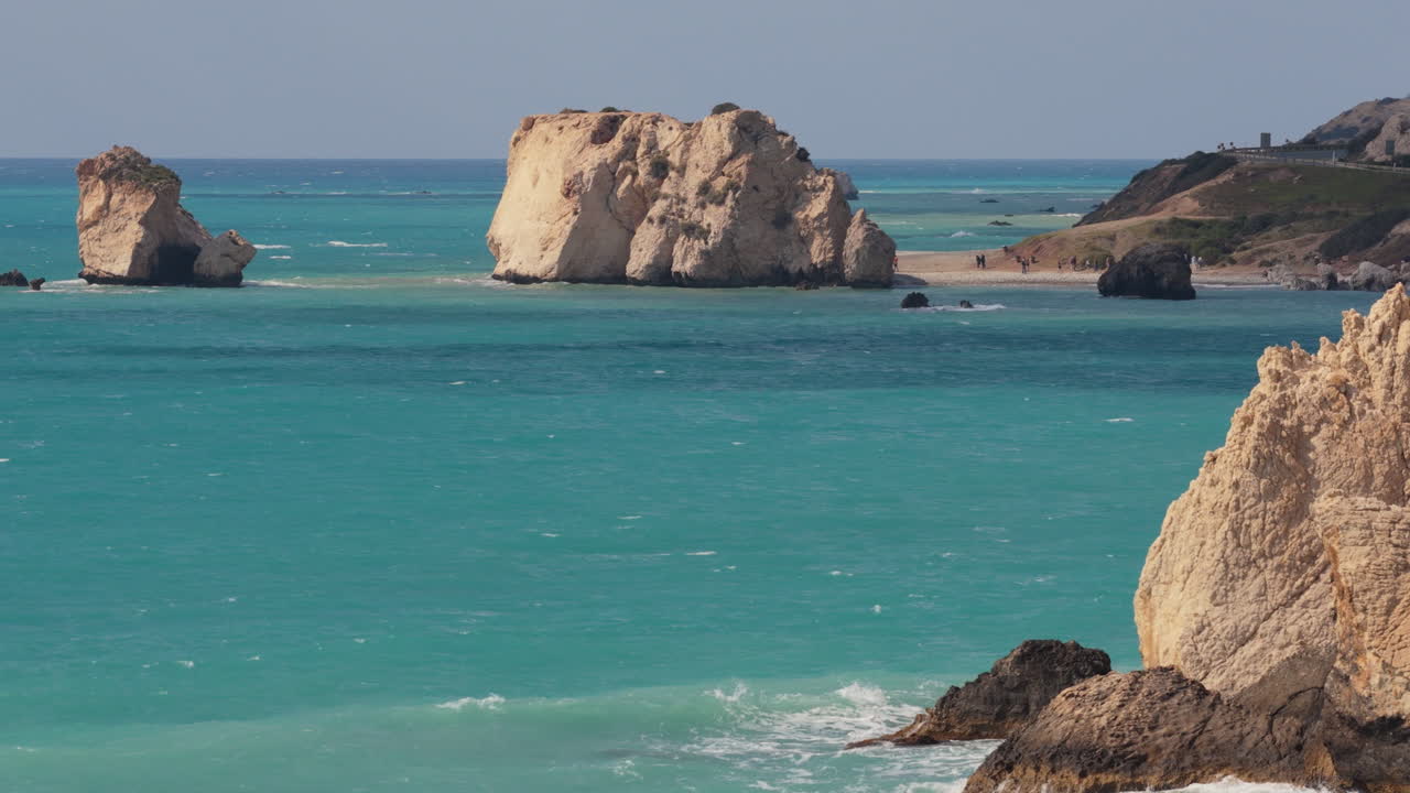 Aerial drone view of Aphrodite's Rock surrounded by turquoise waters and rocky coastline in Cyprus
