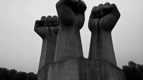 monument of three raised fists in grayscale