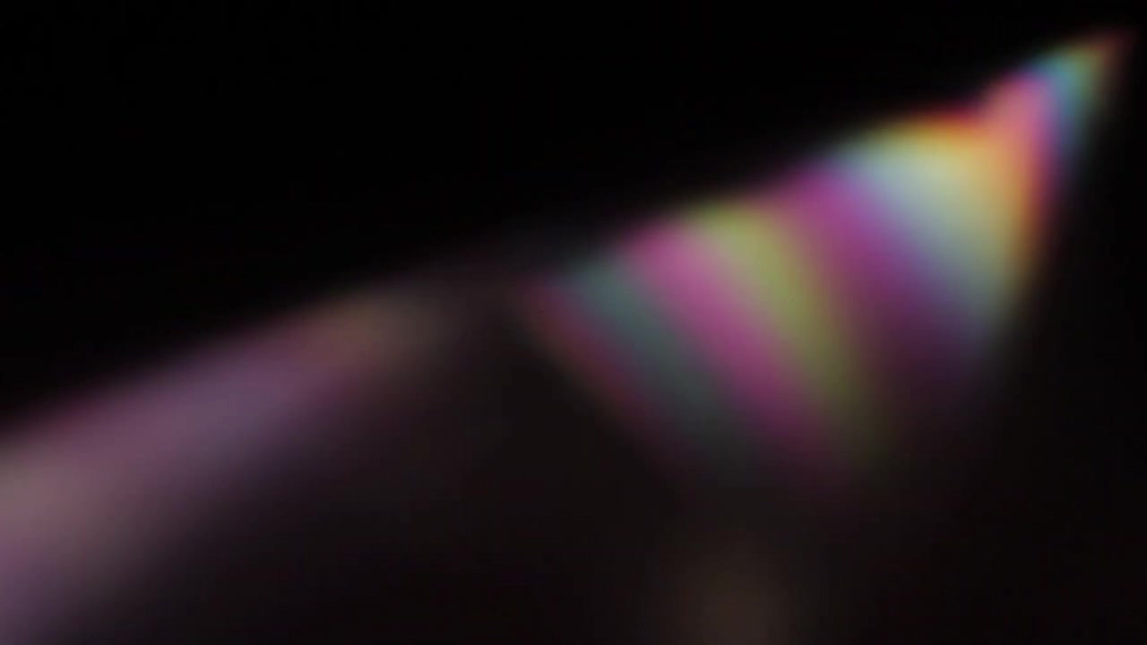 Rifrazione della luce arcobaleno astratta che si muove su sfondo scuro