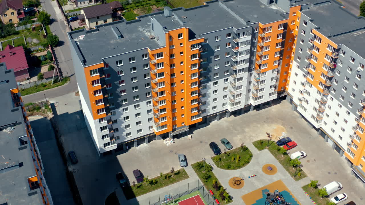 Residential apartment buildings. Colorful walls of a modern high-rise building. Complex of block of flats in the city district. Aerial view.
