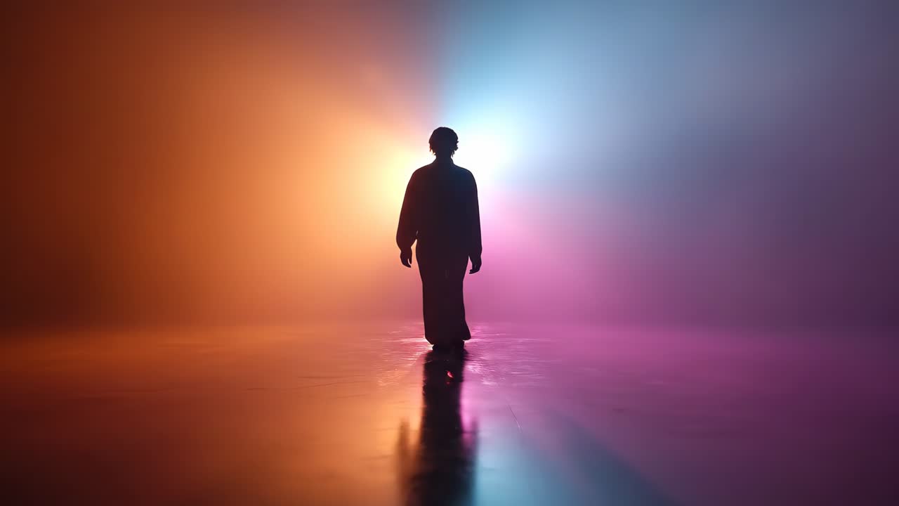 silhouette di persona che cammina verso uno sfondo luminoso e colorato