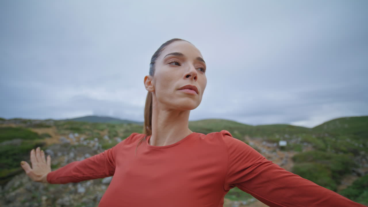 mujer enfocada en primer plano estirándose al aire libre en una mañana nublada. chica atlética