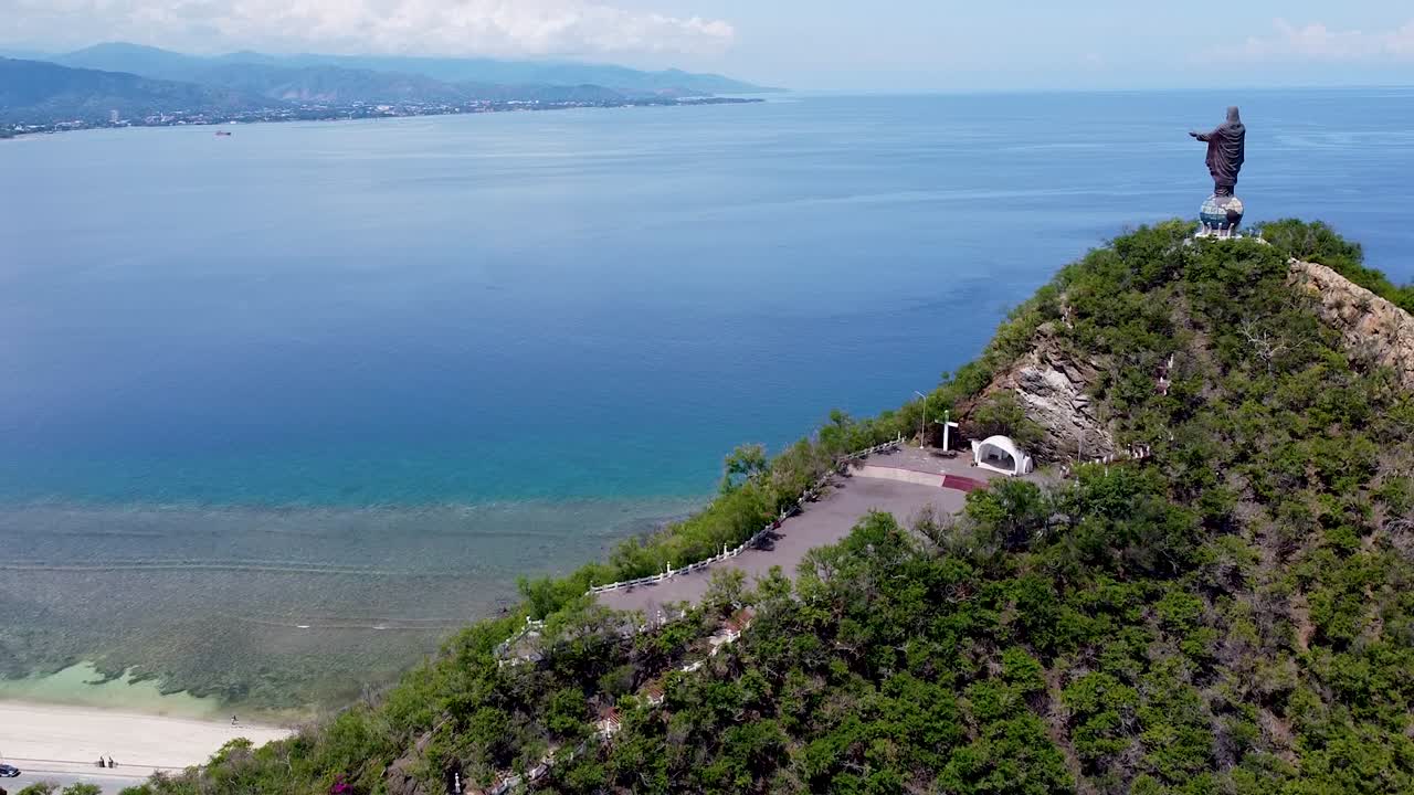 Aerial rising over Cristo Rei landmark statue overlooking ocean views in capital city of Dili, Timor-Leste, Southeast Asia