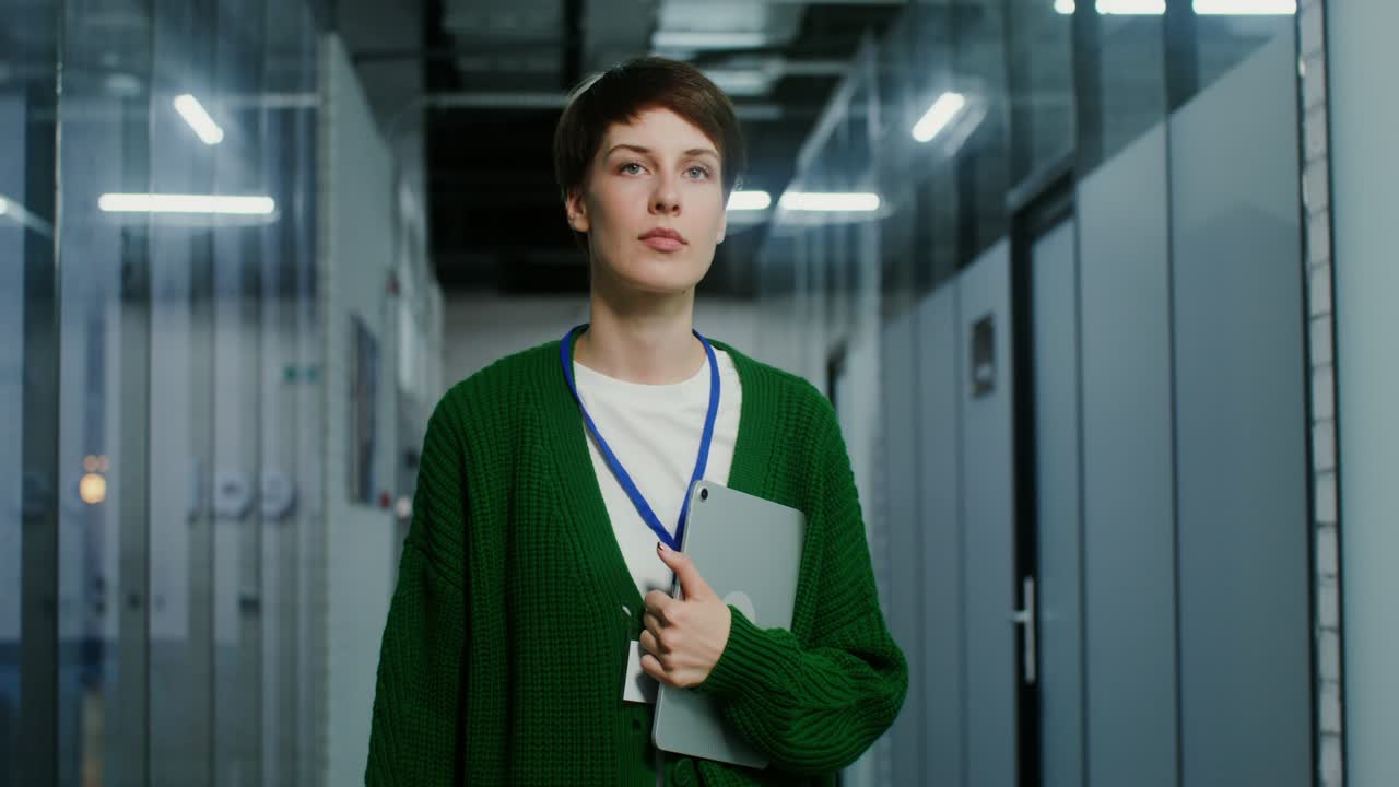 태블릿 을 들고 현대적 인 사무실 복도 에서 고 있는 여자