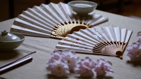 elegant tea ceremony setting with fans and flowers